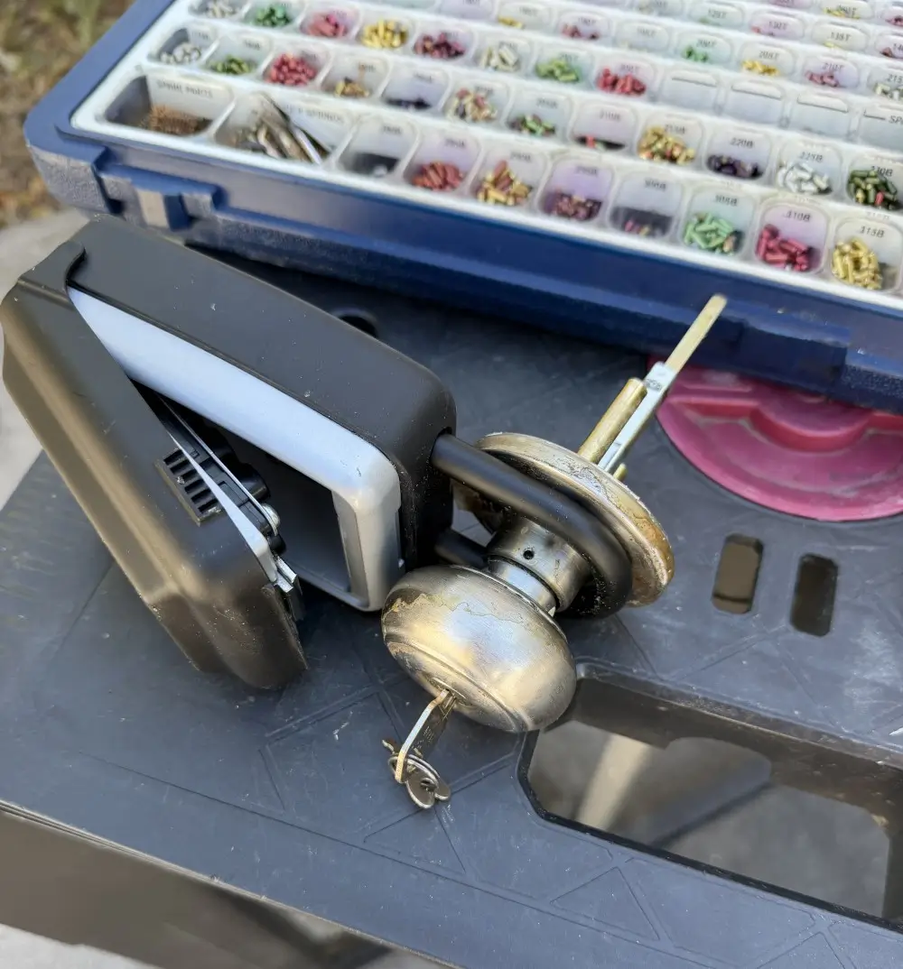 What Does a Lockout Cost in Batesville AR? Real Prices and Response Times for 2026 4 Door knob lock disassembled next to a pinning kit during a mobile rekey job in Batesville AR